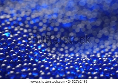 Abstract background in soft selective focus of the blue spherical shape water gel balls, beads or blasters