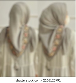 Abstract Background Texture Blur Out Of Focus Two Women In The Same Light Green Muslim Dress And Hijab Seen From Behind