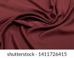 Abstract background texture of natural red color fabric. Fabric texture of natural cotton or linen, silk or satin, wool or jersey textile material. Luxurious red canvas background.
