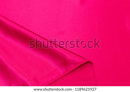 Abstract background texture of natural red color fabric. Fabric texture of natural cotton or linen, silk or satin, wool or jersey textile material. Luxurious red canvas background.
