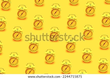 Abstract background trendy summer clock pattern made with yellow retro alarm clock isolated on  bright yellow pastel background.