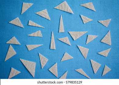 Abstract background with triangular pieces of paper on the fabric blue color