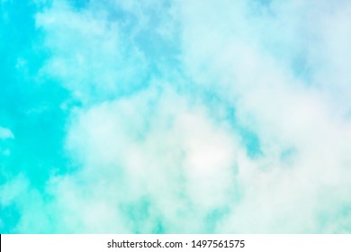 Abstract Background Of A Vibrant Teal Blue Sky With Soft Puffy Clouds