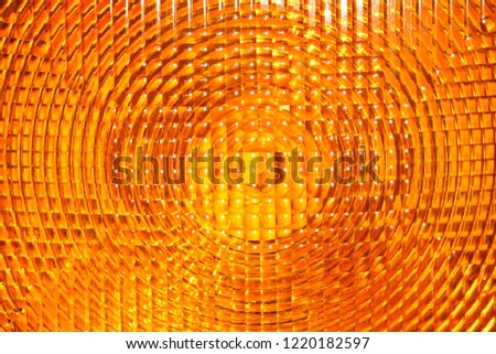 Abstract background of vivid yellow orange faceted plastic reflective surface sign or rear lamp of taillight
