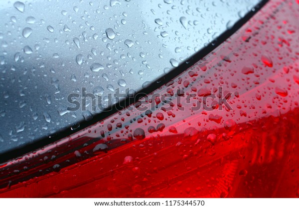 Abstract background of a wet\
automobile detail with drops. Closeup of a car body and\
headlight.