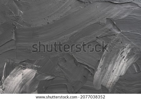 Abstract background. White paint and black ink texture. Macro image of spackling paste. Stroke wallpaper for web and game design. Drywall mud art. Smear of painterly plaster on cardboard.