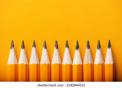 Abstract Background Of Yellow Pencils Lying In A Row. Yellow And Orange Colour Concept