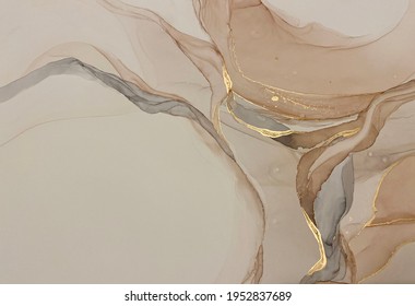 Abstract beige art with gold — pink background with brown, beautiful smudges and stains made with alcohol ink and golden pigment. Beige fluid art texture resembles petals, watercolor or aquarelle.
