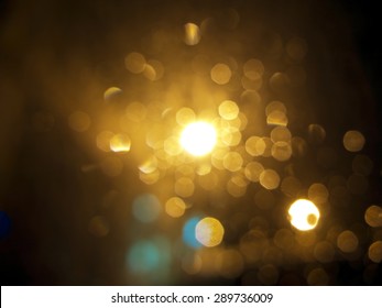 abstract black background, gold bubble lights or snowflakes falling at night. Bokeh Christmas background with circle designs or blurred stars shining, glitter magic background
