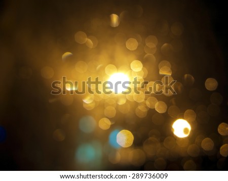 abstract black background, gold bubble lights or snowflakes falling at night. Bokeh Christmas background with circle designs or blurred stars shining, glitter magic background