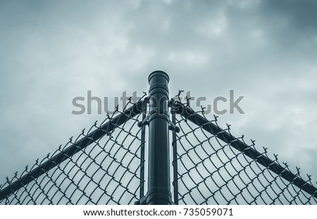 Abstract black chain link fence with white sky background. Black metal chain fence. Chrome steel chain fence, Symmetrical design. Industrial design. Industrial fence. Black and white. Steel frame.