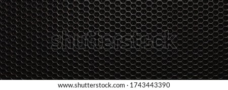Abstract black metallic mesh texture for background. Industrial backdrop. The speaker of a musical column. Panoramic horizontal high-resolution photography. Design element. Close up. Copy space. 
