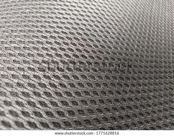 Abstract black nylon synthetic fabric. Gray\
artificial fabric mesh, resistant to pollution. Fragment of a child\
car seat close-up. Soft\
focus