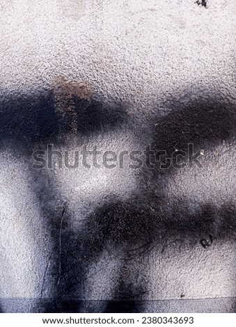 Abstract black paint stroke background. Hand painted black strokes on old cement wall. Dirty concrete cement wall with black paint stains. Abstract black paint grunge background.
