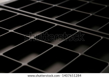 Abstract black plastic surface from diagonal concave rectangles
