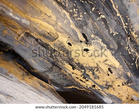 Abstract black and white art with golden paint — gold background with beautiful smudges, stains, stokes and smears made with alcohol ink. Gold fluid texture resembles oil painting, marble, stone.