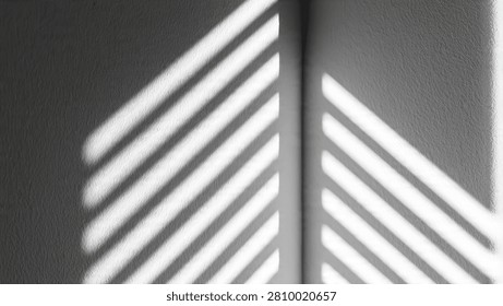 Abstract black and white composition featuring sharp diagonal shadows cast by window blinds onto a textured wall corner.