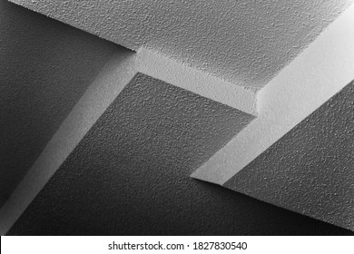 Abstract black and white image of intersection of four different popcorn ceiling panels at different heights