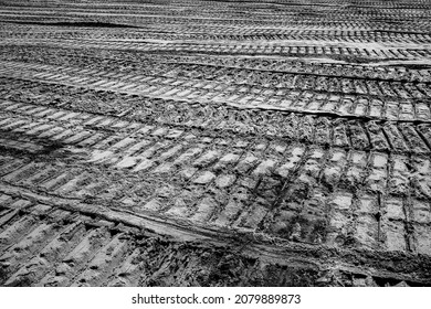abstract black and white image of tire tracks of construction vehicles in sand on a construction site - Powered by Shutterstock