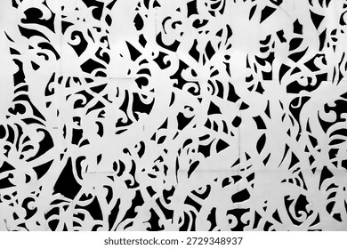 an abstract black and white pattern composed of swirling, organic shapes, laser-cut metal screens, fences, and various forms of artwork