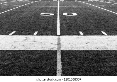 Abstract black and white photography of football field. Fifty 50 yard line of sports football field. Grass turf field. Abstract sports photography.