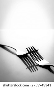 Abstract black and white shadow pattern created by crossed forks