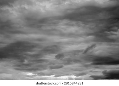 Abstract black and white texture of dramatic storm clouds covering the sky. Moody weather background with layered cloud formation and natural atmosphere.