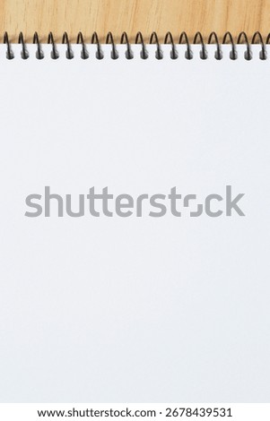abstract blank backdrop: close up of empty page of notepad with spiral binder laying on wooden table