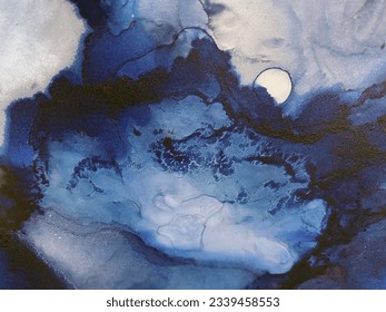 Abstract blue art with yellow gold — blue background with golden paint. Beautiful smudges and stains made with alcohol ink. Blue fluid art texture resembles stone, watercolor or aquarelle.