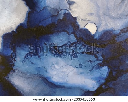 Abstract blue art with yellow gold — blue background with golden paint. Beautiful smudges and stains made with alcohol ink. Blue fluid art texture resembles stone, watercolor or aquarelle.
