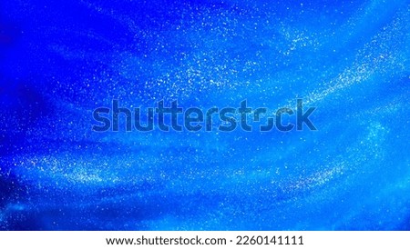 Abstract blue background with tints of silver sparkles. Liquid glitter background with small glowing particles. Blue flowing waves textured background with white streaks.