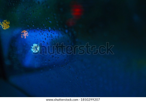 Abstract blue\
hour raining on the car wind\
screen