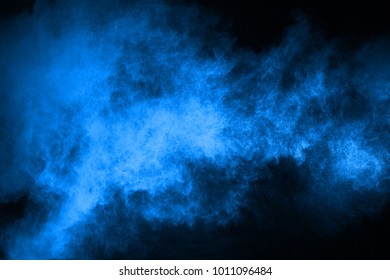 abstract blue powder splatted background,Freeze motion of color powder exploding/throwing color powder,color glitter texture on black background. - Shutterstock ID 1011096484