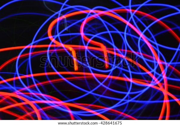 Abstract blue and red streaks of light on\
a black dark background creates a unique\
pattern.