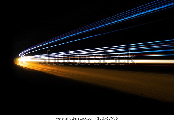 Abstract blue, yellow and white rays of light in a\
car tunnel