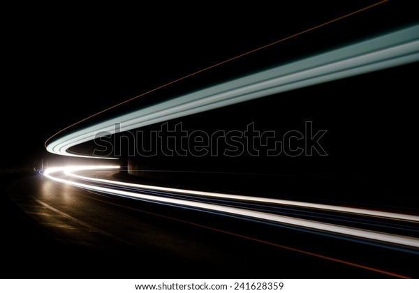 Abstract blue, yellow and white rays of light in a\
car tunnel