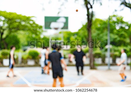 Abstract blur background about the street basketball which including of the player with the ball and Basketball hoop.