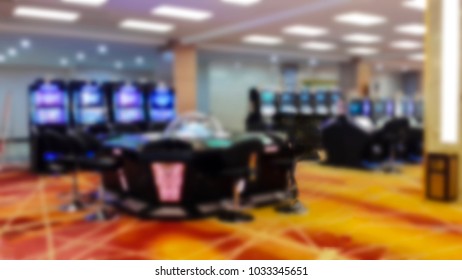 Abstract Blur Background With Gambliing Room, Roulette On Table, Poker Table And Slot Machine, No People In Image