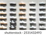 Abstract Blur Background of Row of shoes on display in shop. A view of a wall of shoes inside the store. Modern new stylish sneakers running shoes.