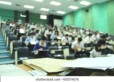 Abstract Blur Background Of Student During Study Or Quiz, Test And Exams From Teacher Or In Large Lecture Room / University Classroom.