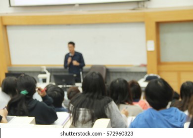 Abstract Blur Background Of Students During Study Or Quiz, Test And Exams From Teacher Or In Large Lecture Room / University Classroom.