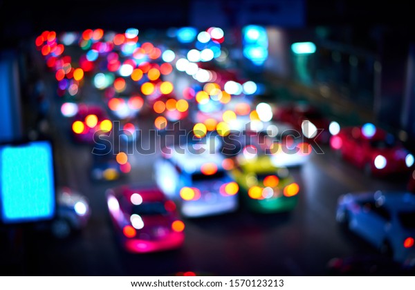 Abstract Blur blue neon city night light,\
with busy traffic with cars and colorful tail light as bokeh, with\
copyspace of small blue billboard.\
