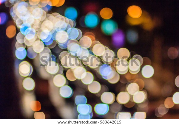 Abstract blur bokeh of Evening traffic jam on road\
in city. Out of focus lights from cars in a traffic jam. Defocused\
lights car traffic jam of a street road at night. Road traffic jam\
blur focus