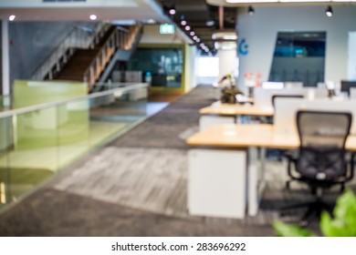 Abstract blur business office working space background with modern interior with table and chair with devices. Blurry creative workplace design background
