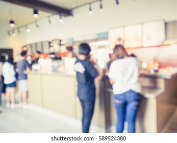 Abstract Blur Of Cashier In Coffee Shop With Asian Customers In Queue - Vintage Filter