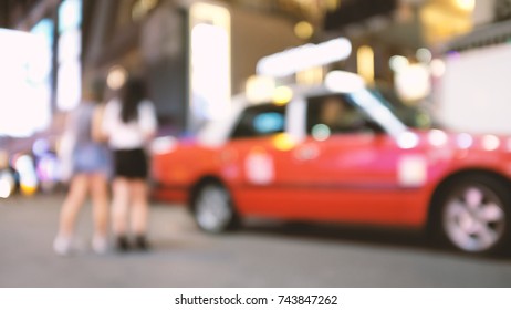 Abstract Blur And Defocused Passengers Getting Urban Red Taxi At Night In Hong Kong For Background, Old Film Look Effect