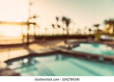 Abstract blur and defocused swimming pool in hotel resort in sunrise for background - vintage tone