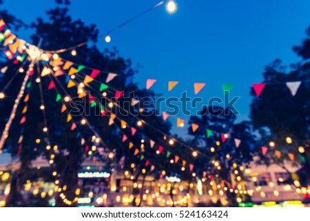 abstract blur image of food stall at night market festival for background usage . (vintage tone)