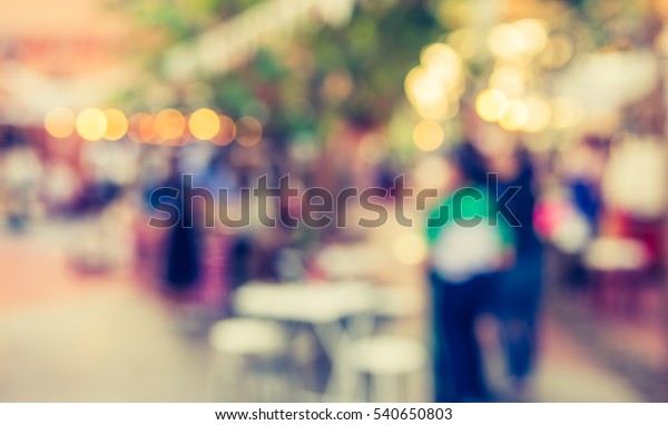 abstract blur image of food stall at day\
festival for background usage. (vintage\
tone)