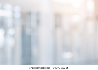 abstract blur modern interior inside entrance building of office in pale blue background with orange light effect concept